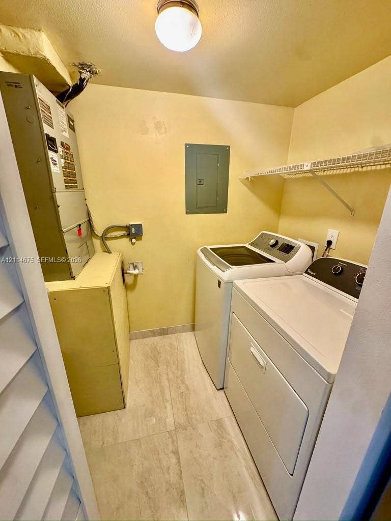 Utility area featuring tile flooring, ceiling-mounted lighting, and built-in wire shelving