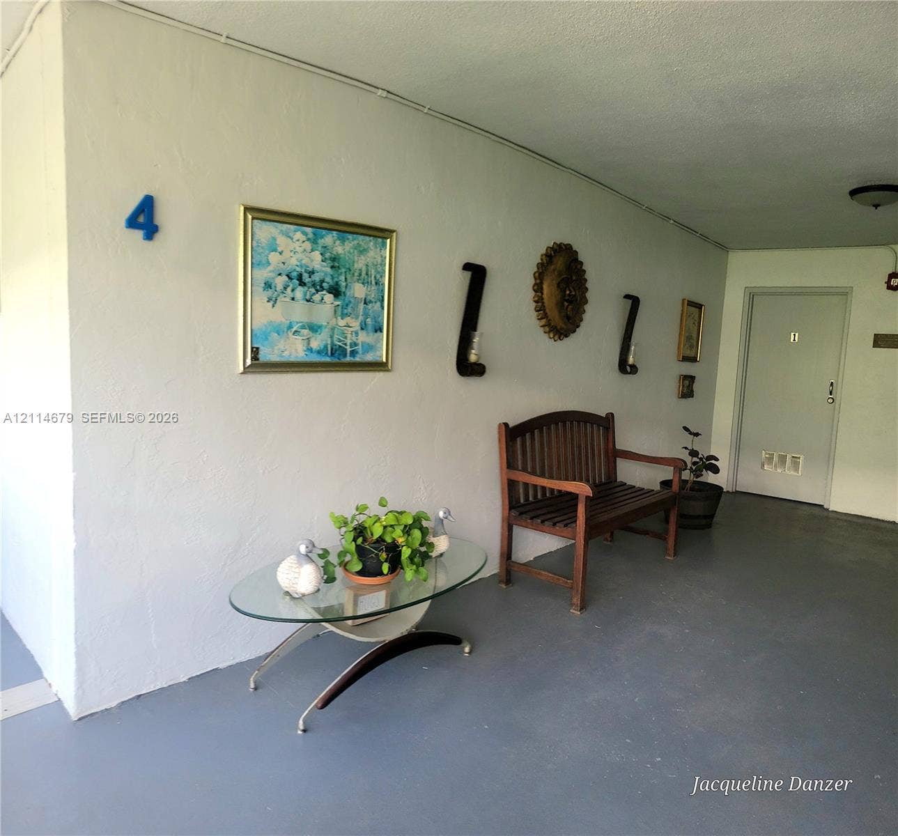 Covered entryway featuring a solid-surface floor, smooth wall finish, and an exterior door