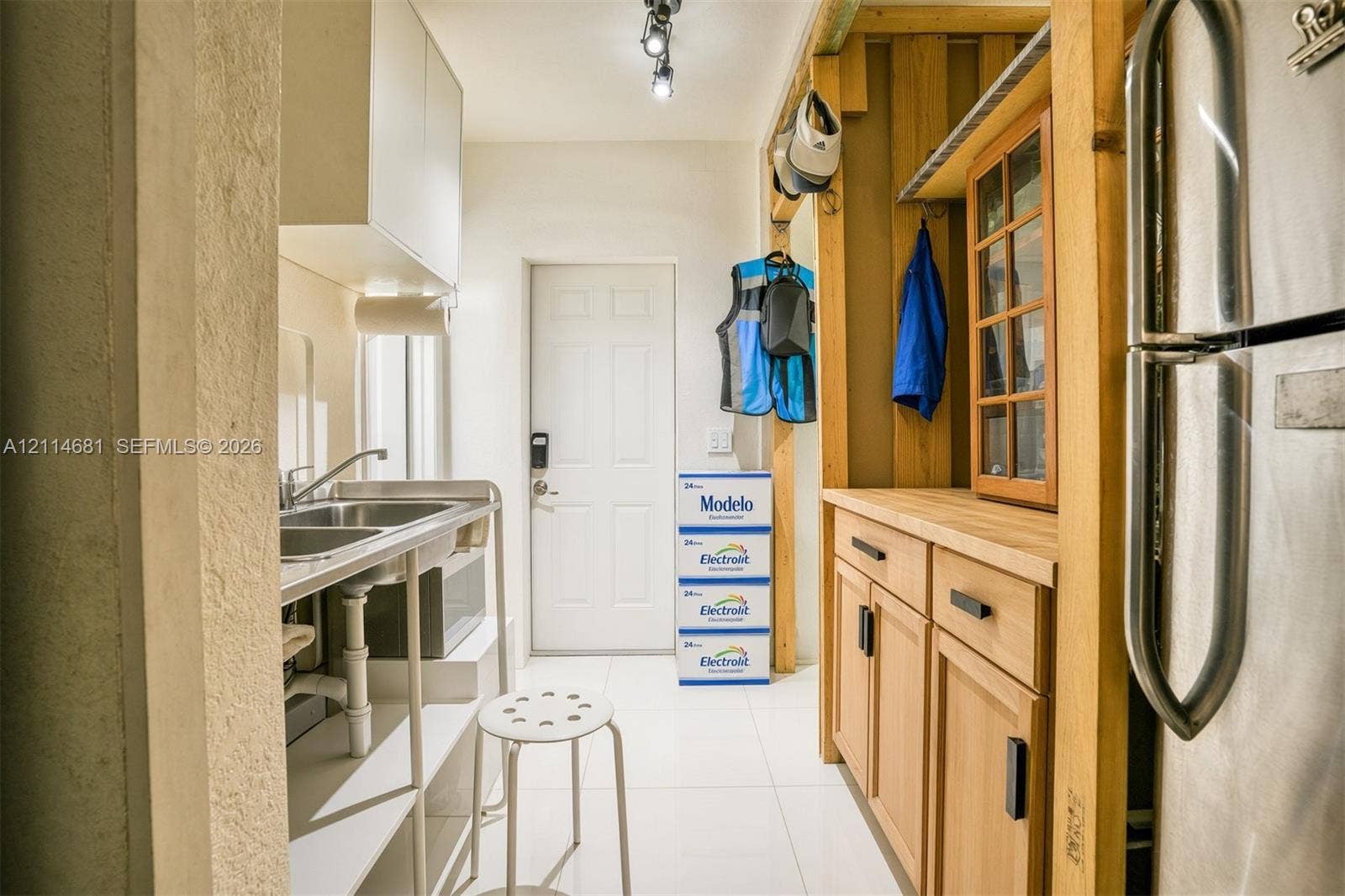 6700 NW 5th Avenue, Miami, FL 33150 Utility area featuring light wood-finish cabinetry, a butcher block countertop, a stainless steel dual-basin sink, and white tile flooring