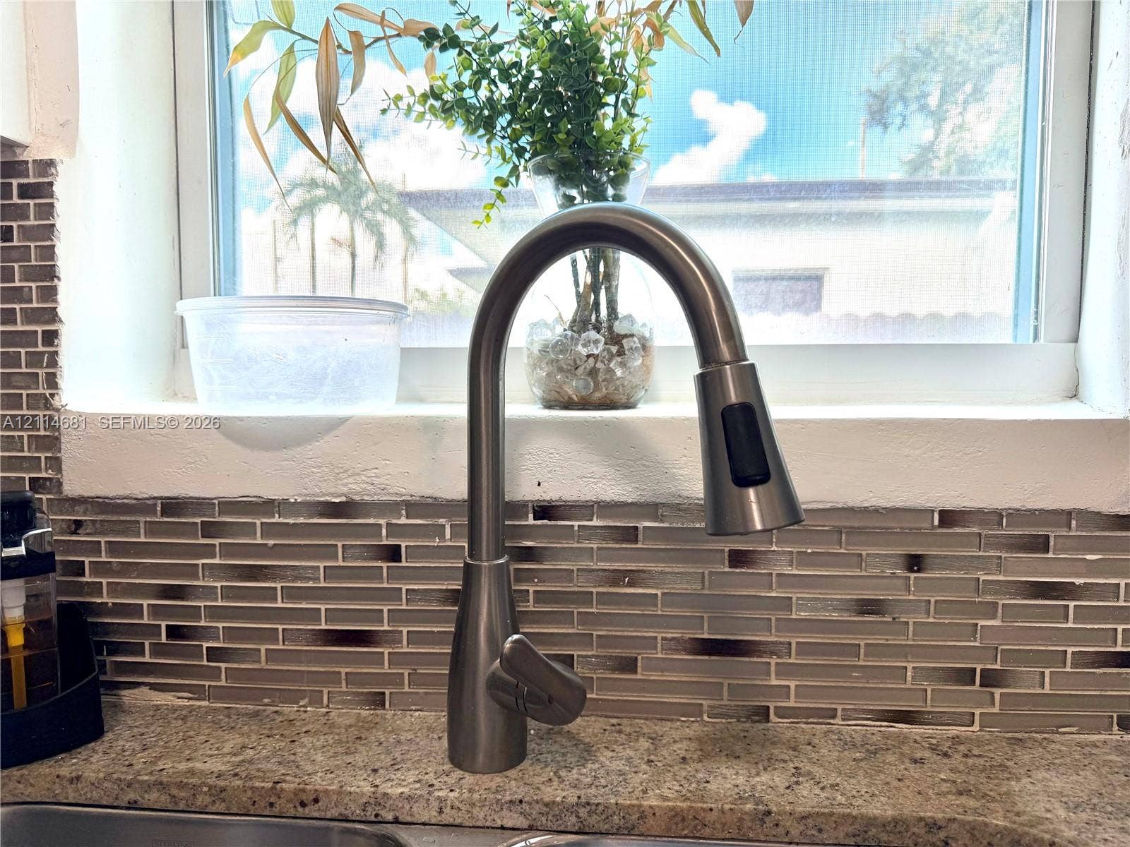 6700 NW 5th Avenue, Miami, FL 33150 Brushed nickel high-arc pull-down faucet featuring stone-composite countertop and horizontal multi-toned glass tile backsplash
