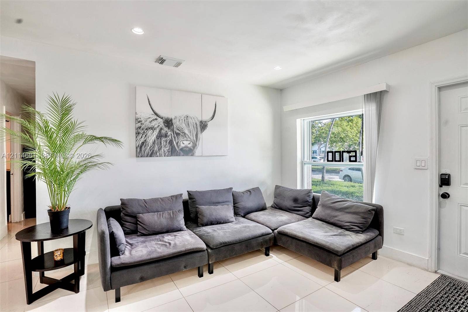 6700 NW 5th Avenue, Miami, FL 33150 Neutral-toned interior featuring large-format ceramic tile flooring, recessed lighting, and a window providing natural light