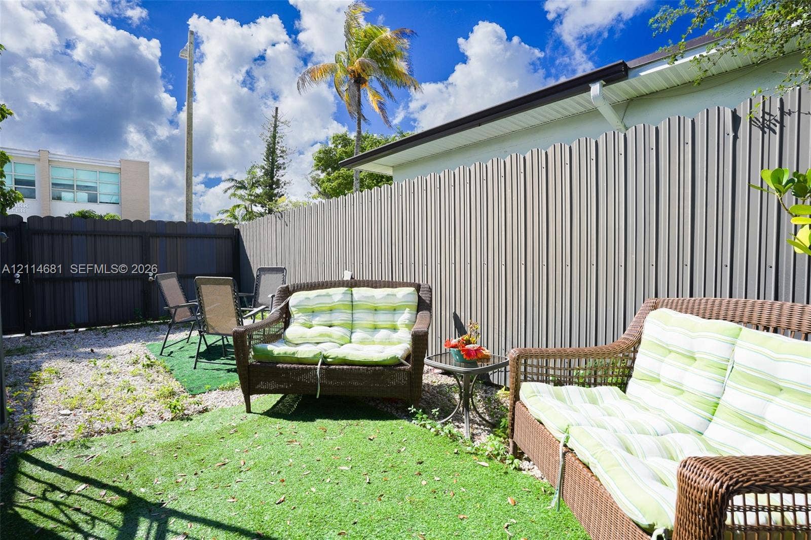 6700 NW 5th Avenue, Miami, FL 33150 Enclosed outdoor patio space featuring corrugated metal privacy fencing and synthetic turf ground covering