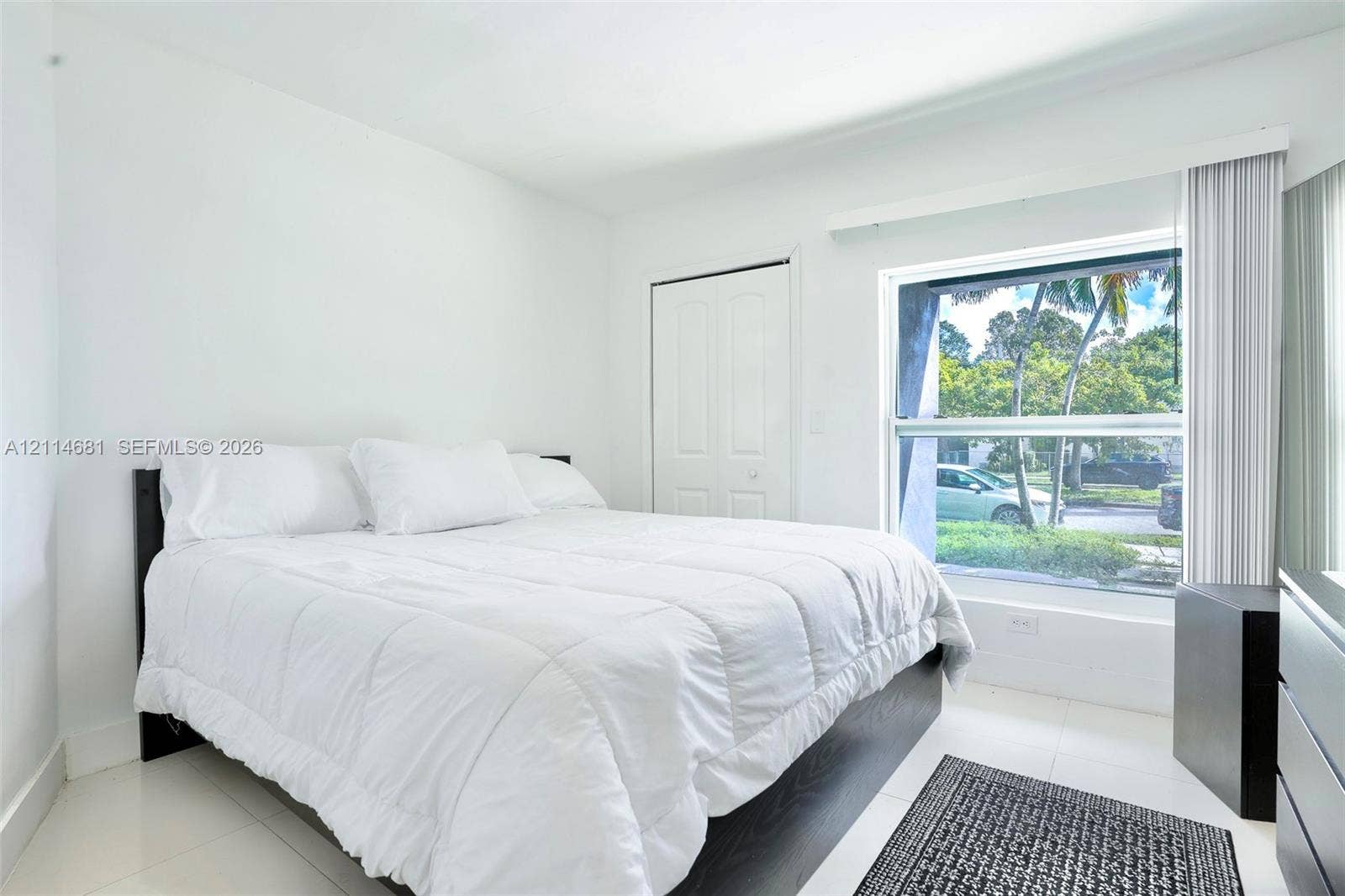 6700 NW 5th Avenue, Miami, FL 33150 Room featuring neutral-toned ceramic tile flooring, a large horizontal window, and a built-in closet with double doors