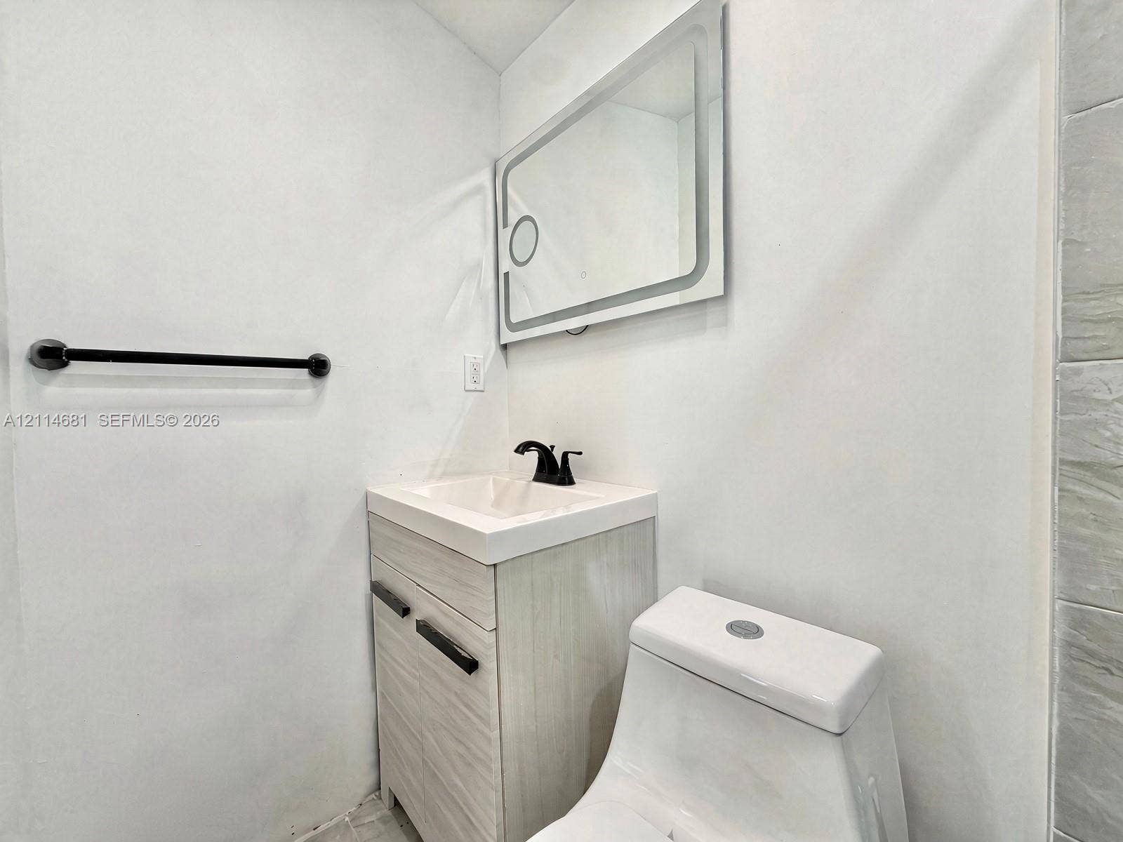 6700 NW 5th Avenue, Miami, FL 33150 Modern vanity with a rectangular sink, matte black faucet, wall-mounted rectangular LED mirror, and matte black towel bar