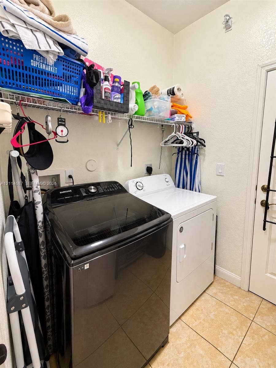 Laundry room featuring tile flooring, wall-mounted wire shelving, and a solid-core door