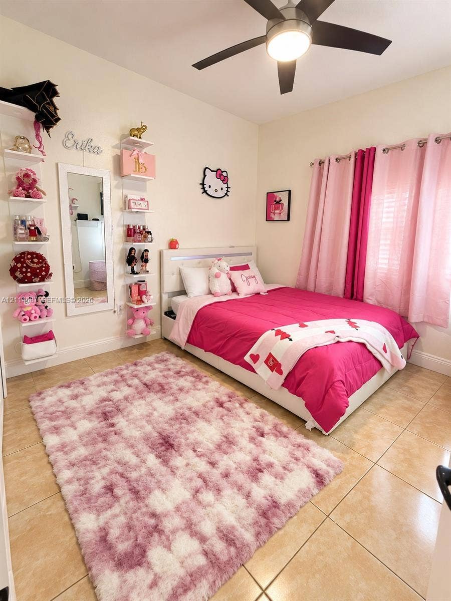 Ceramic tile flooring, built-in wall-mounted shelving, central ceiling fan with integrated lighting, and window with grommet-top drapery