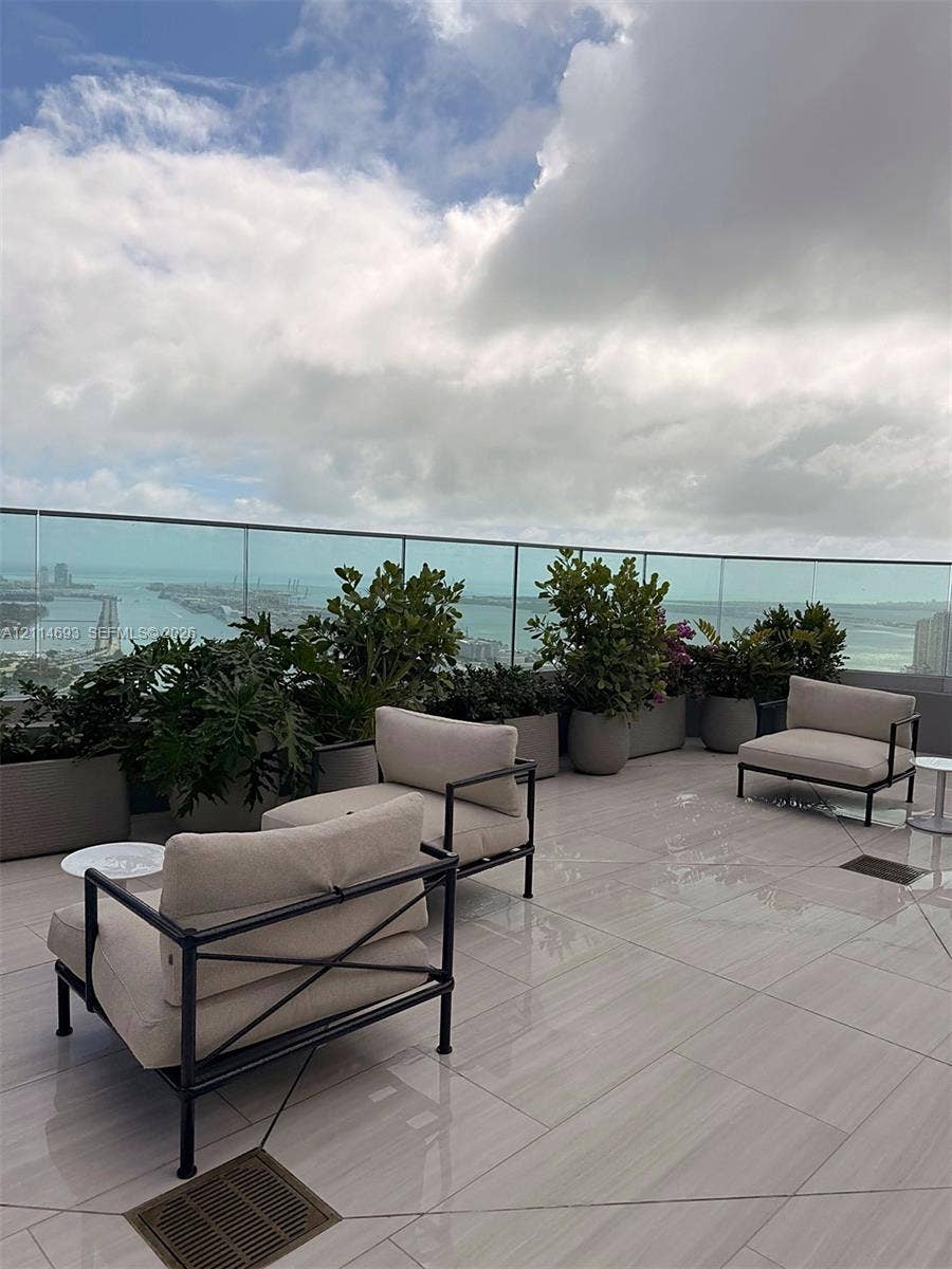 Expansive terrace featuring large-format tile flooring and a seamless glass railing