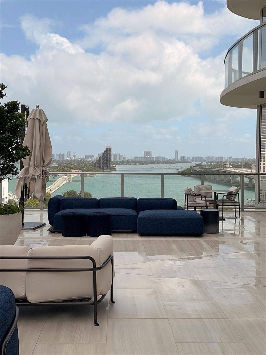 Expansive outdoor terrace featuring large-format tile flooring and a glass panel railing