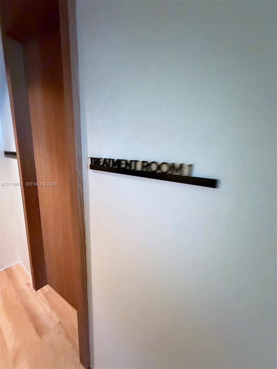Wood-finish door casing and matching wood-finish flooring with three-dimensional wall signage