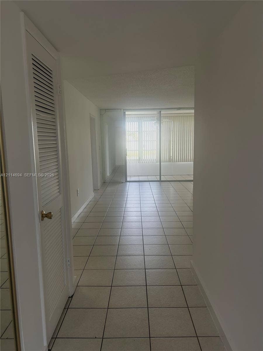 8600 Sunrise Lakes Boulevard, #211, Sunrise, Sunrise, FL 33322 Interior area featuring square tile flooring, louvered closet door, and glass sliding doors