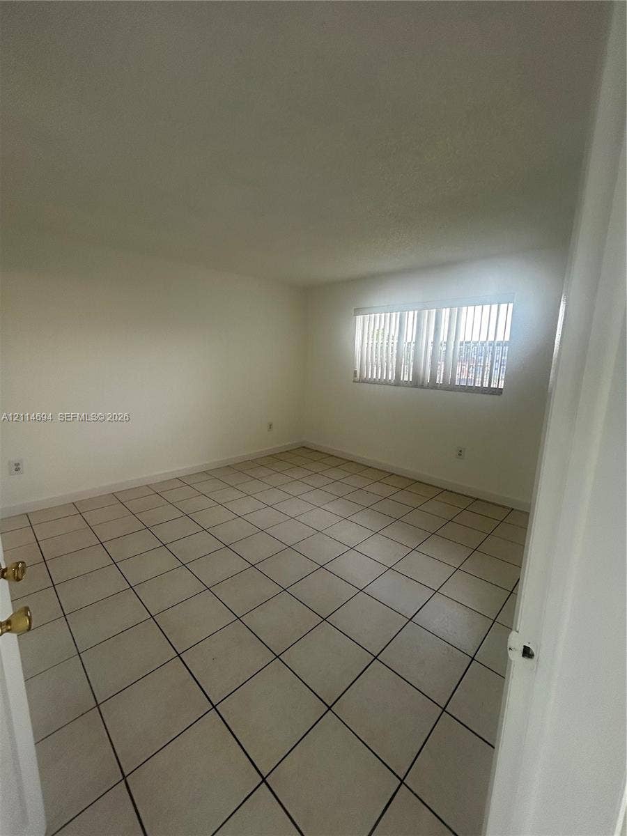 8600 Sunrise Lakes Boulevard, #211, Sunrise, Sunrise, FL 33322 Neutral-toned interior space featuring ceramic tile flooring and vertical window blinds