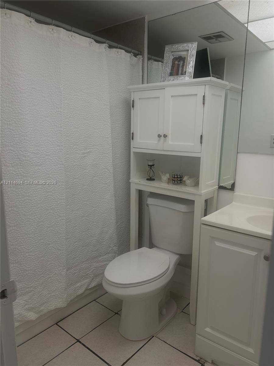 8600 Sunrise Lakes Boulevard, #211, Sunrise, Sunrise, FL 33322 Bathroom featuring light-toned tile flooring, built-in white cabinetry, and a full-width vanity mirror