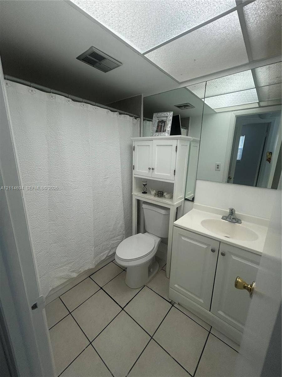 8600 Sunrise Lakes Boulevard, #211, Sunrise, Sunrise, FL 33322 Bathroom featuring a vanity with an integrated countertop sink, full-width mirror, three-light fixture, and geometric patterned floor tiling