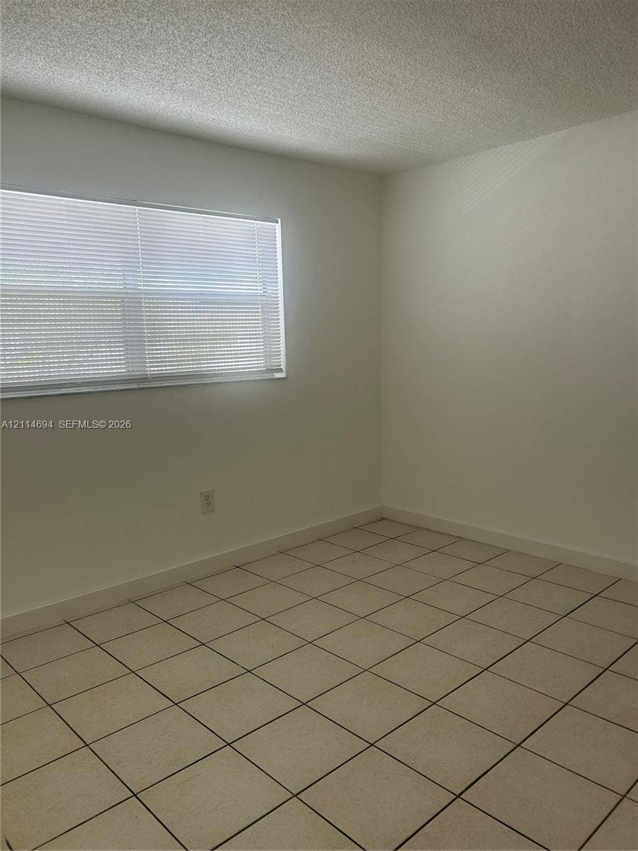 8600 Sunrise Lakes Boulevard, #211, Sunrise, Sunrise, FL 33322 Neutral-toned ceramic tile flooring, solid white wall finishes, and a window with horizontal blinds