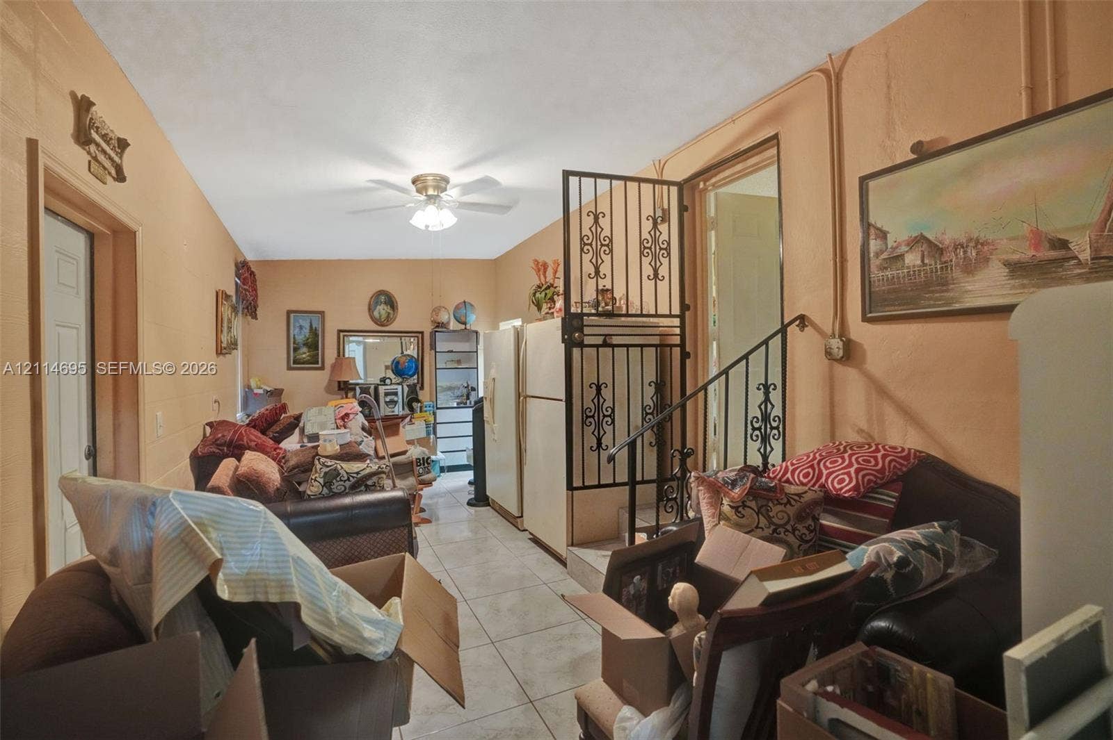 Tile flooring, ceiling fan, and ornate metal stair railing