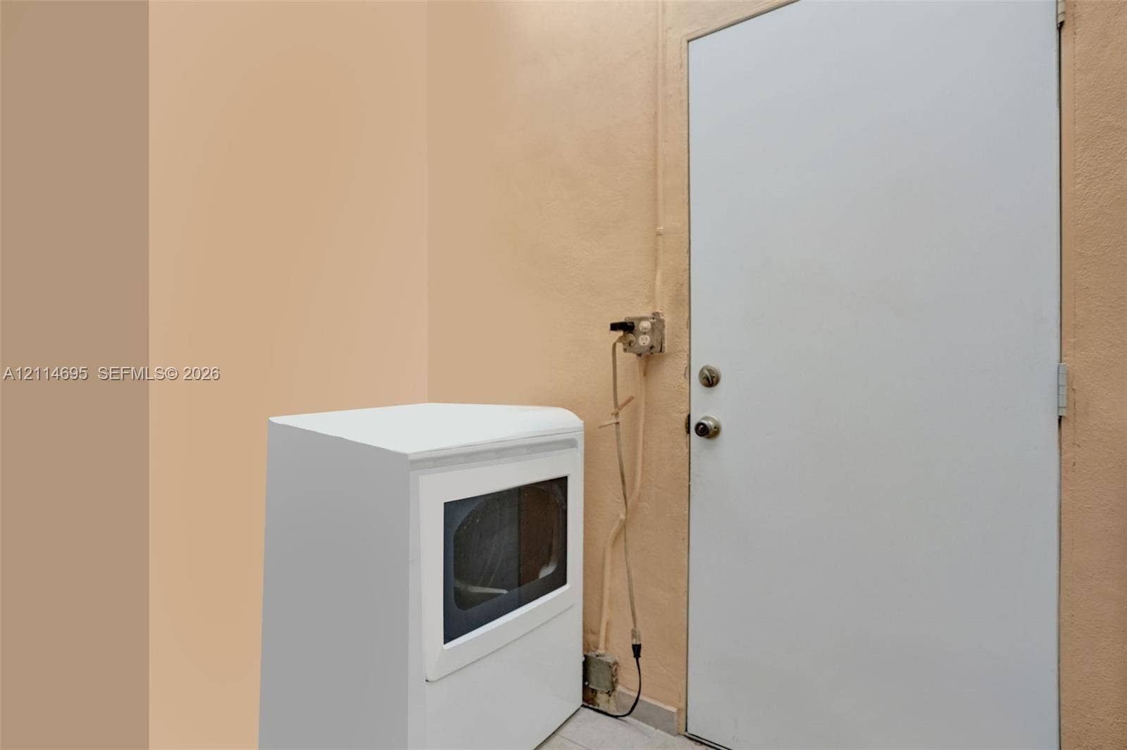 Utility area featuring a white appliance with a glass door panel and a solid white swing door