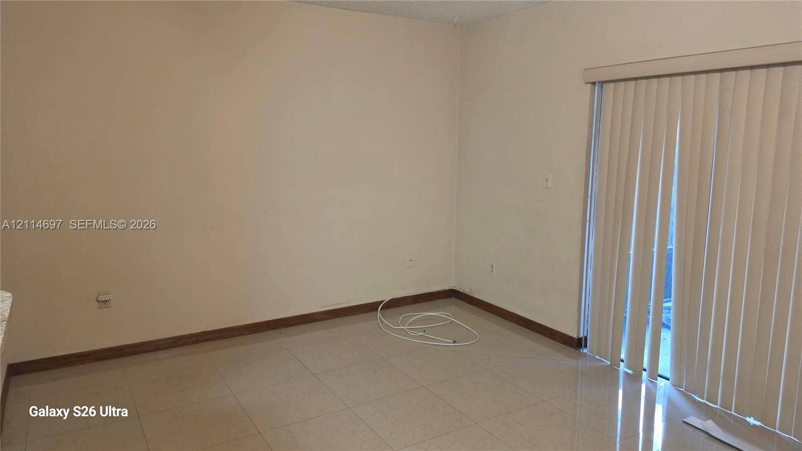 121 SW 113th Avenue, #104-10, Sweetwater, Sweetwater, FL 33174 Neutral-toned wall finish, large-format tile flooring, and vertical sliding glass door with integrated blinds