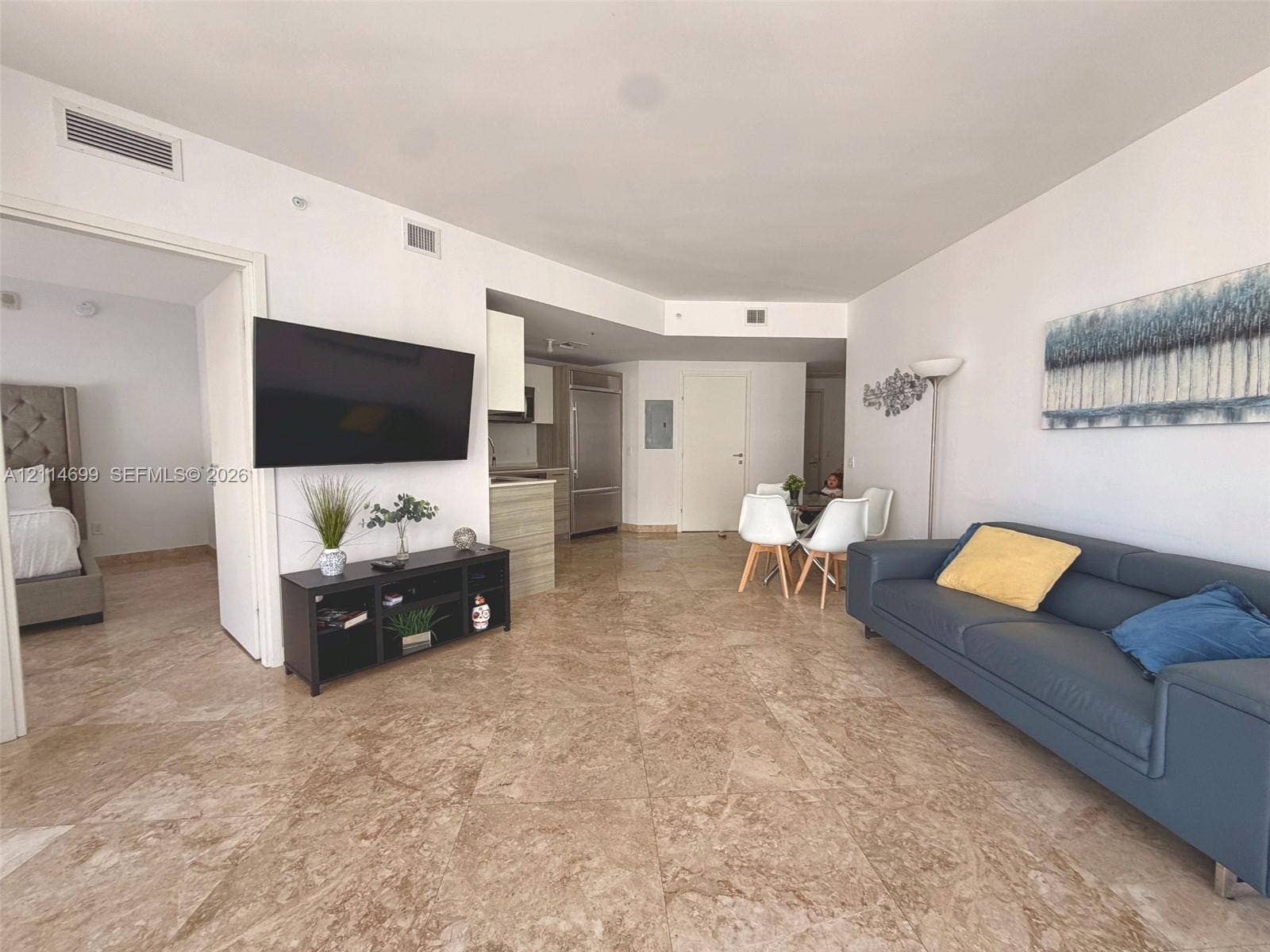1300 Brickell Bay Drive, #3007, Miami, FL 33131 Open-concept interior featuring large-format stone tile flooring, high ceilings, built-in stainless steel refrigerator, and recessed lighting