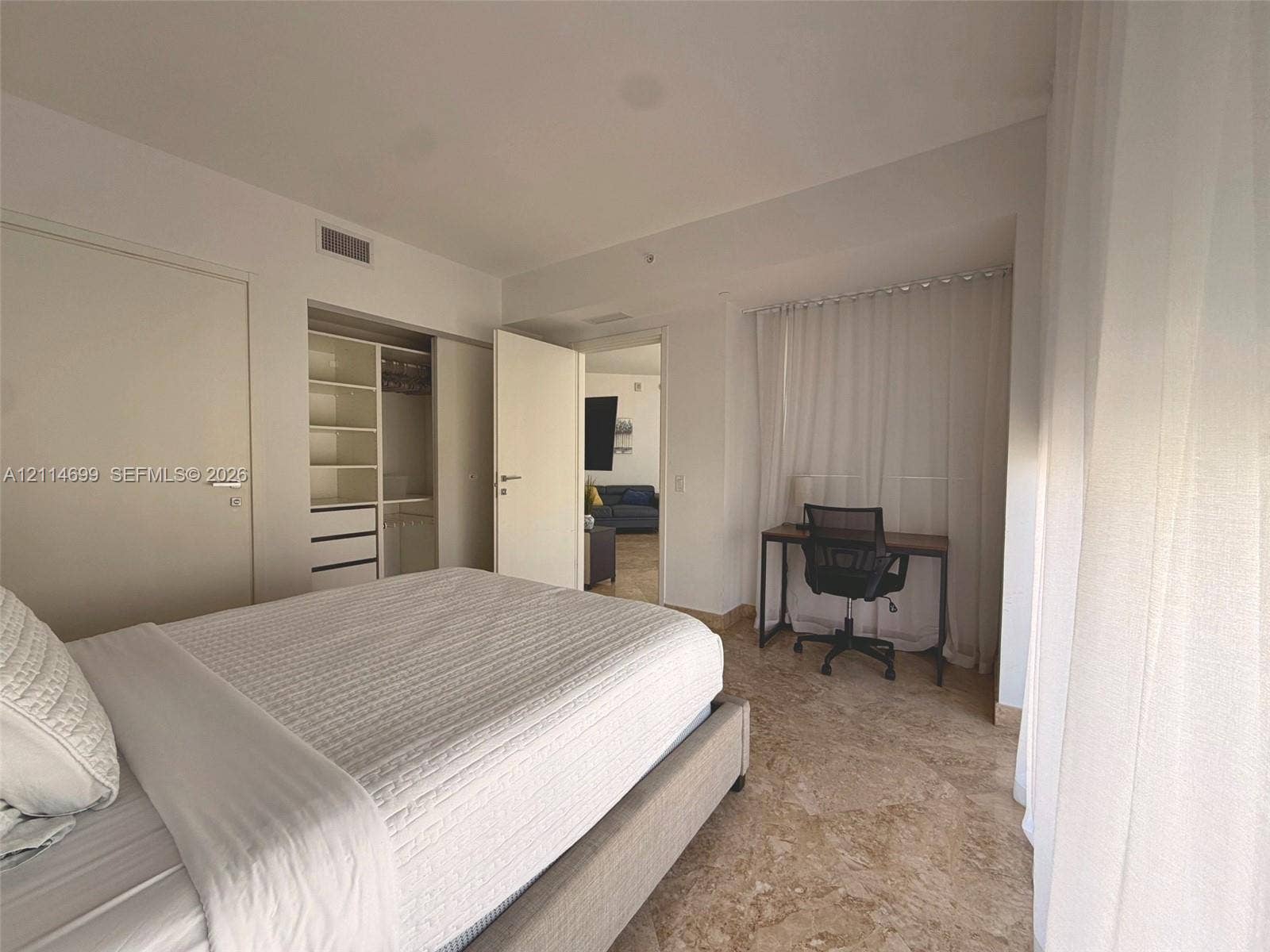 1300 Brickell Bay Drive, #3007, Miami, FL 33131 Stone flooring, custom built-in closet organization system with shelving and drawers, and floor-to-ceiling drapery