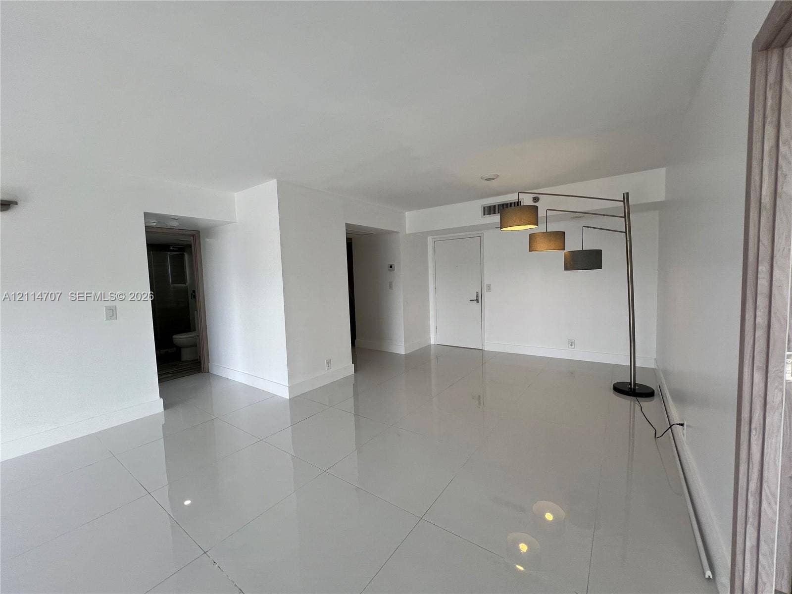 3300 NE 191st Street, #1405, Aventura, Aventura, FL 33180 Open interior space featuring high-gloss large-format tile flooring, neutral wall finishes, recessed ceiling lighting, and solid-core interior doors