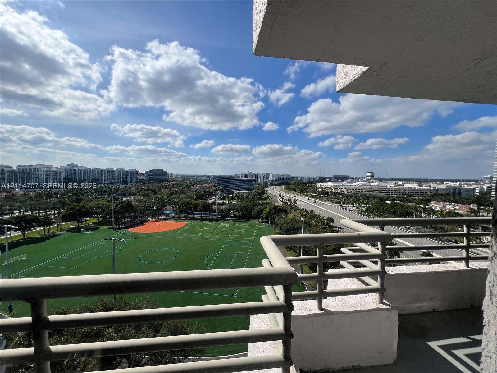 3300 NE 191st Street, #1405, Aventura, Aventura, FL 33180 Private balcony with metal railings overlooking an athletic complex and municipal landscape