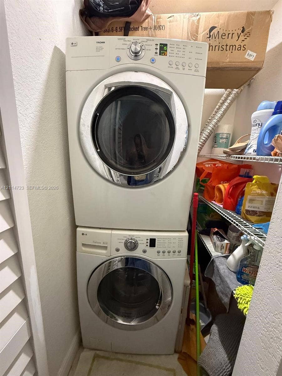 Stackable front-load laundry unit featuring a digital control panel and wire shelving