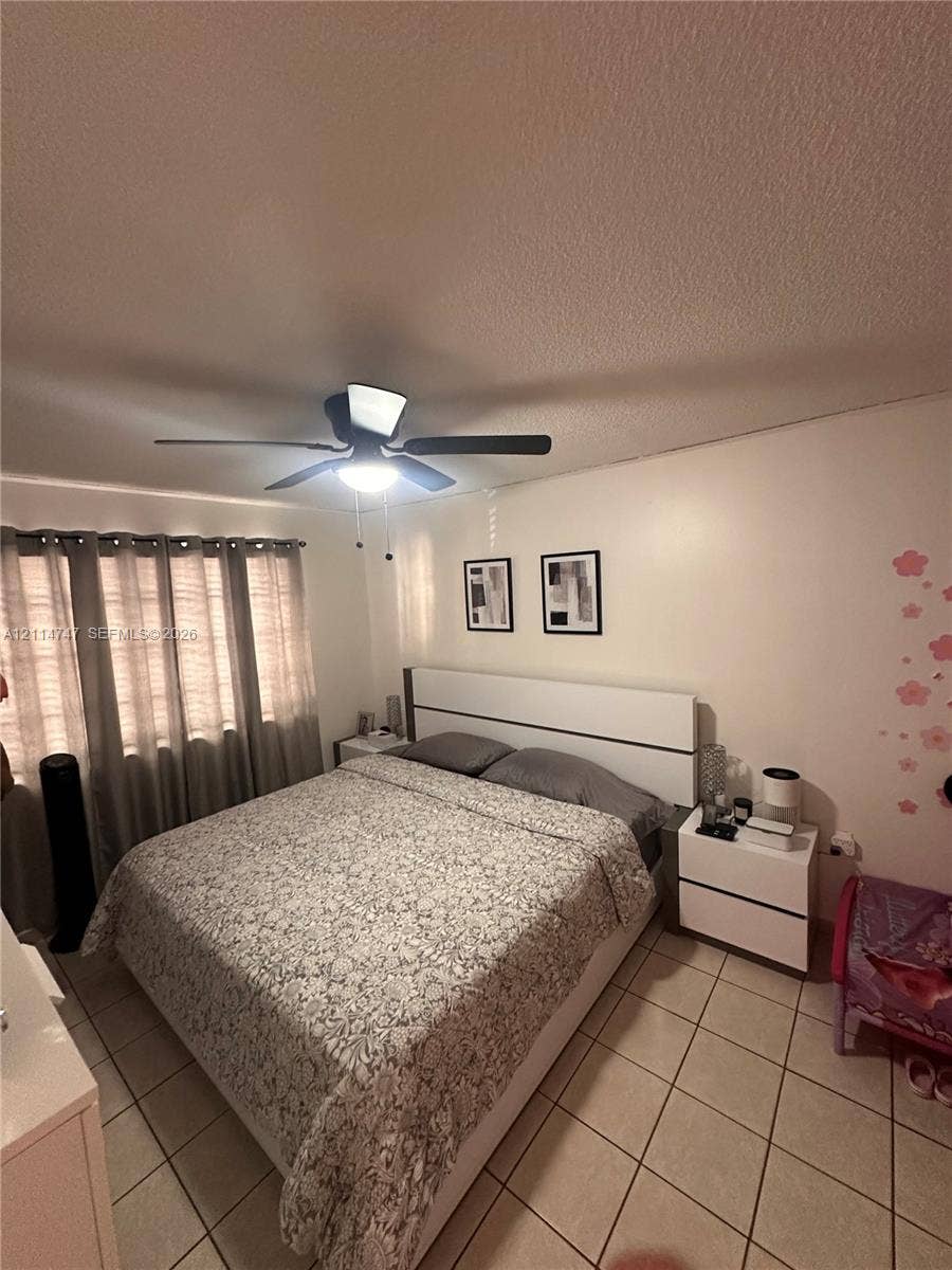 1285 W 26th Place, #202, Hialeah, Hialeah, FL 33010 Ceramic tile flooring, neutral wall tones, and a ceiling-mounted light fixture with integrated fan
