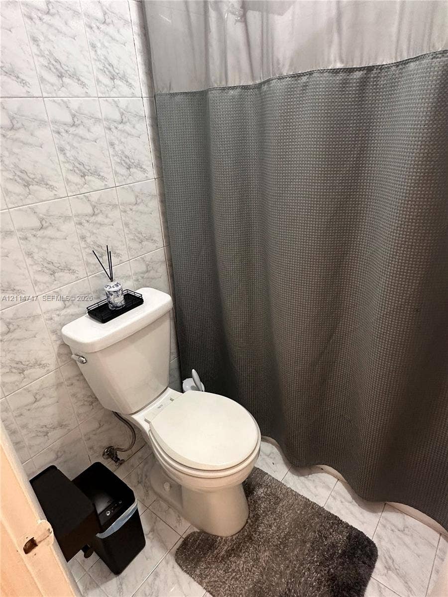 1285 W 26th Place, #202, Hialeah, Hialeah, FL 33010 Bathroom featuring light-toned stone-patterned wall and floor tiling