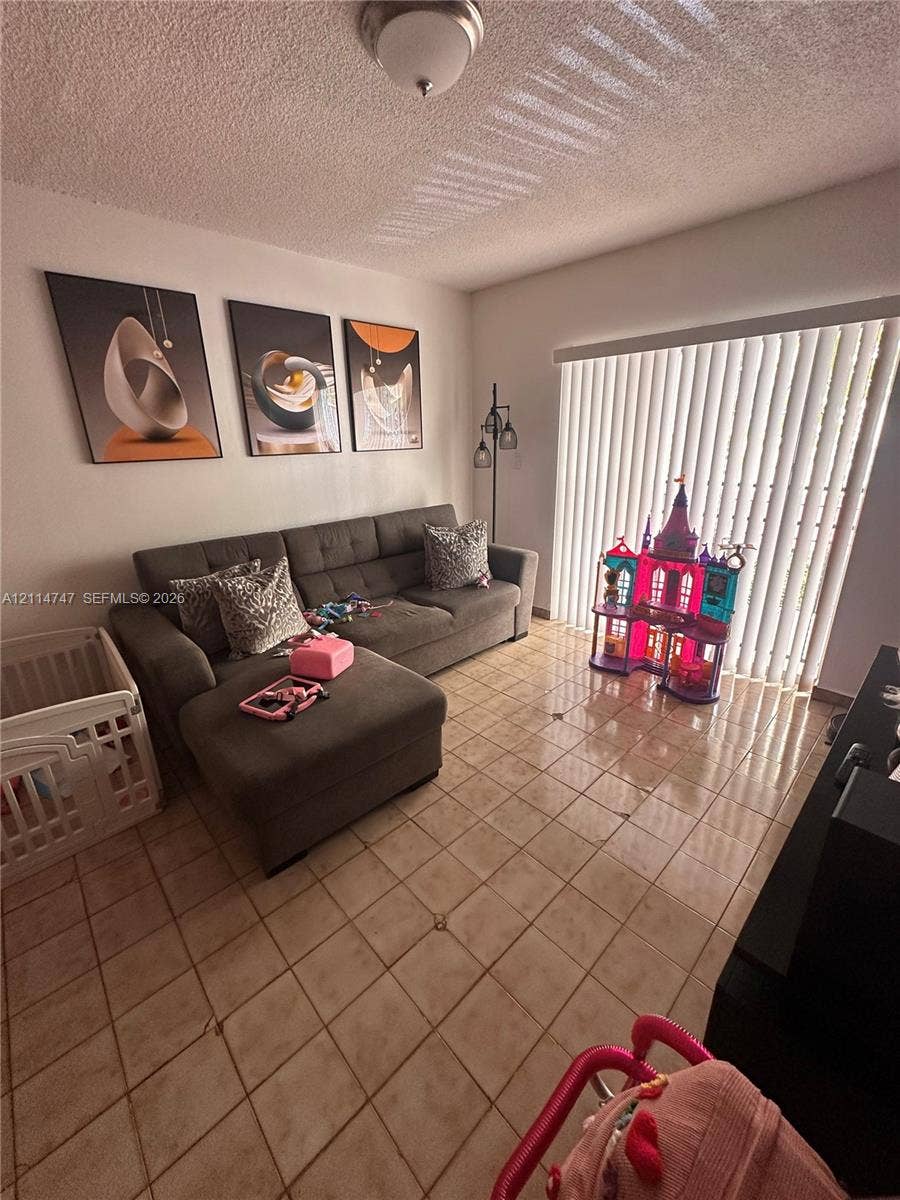 1285 W 26th Place, #202, Hialeah, Hialeah, FL 33010 Interior space featuring tile flooring, ceiling-mounted light fixture, and floor-to-ceiling vertical blinds
