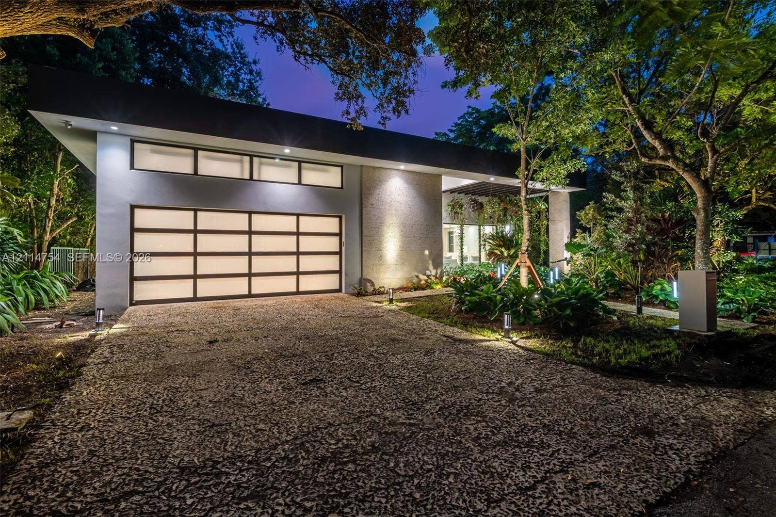 6731 SW 64th Avenue, South Miami, FL 33143 Aerial perspective featuring a rectangular swimming pool, central open-air courtyard with stone landscaping, multi-section metal roofing, and mature perimeter trees