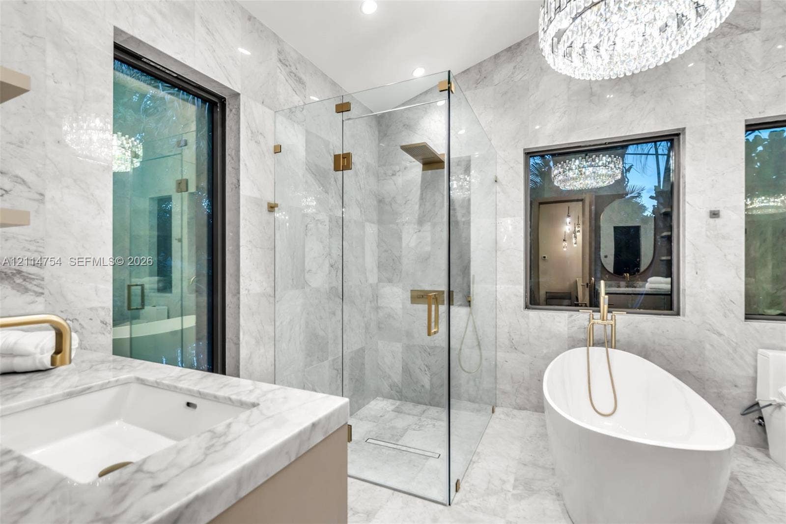 6731 SW 64th Avenue, South Miami, FL 33143 Vaulted ceilings, large-format tile flooring, floor-to-ceiling glass sliding doors, modern circular chandelier, and recessed lighting