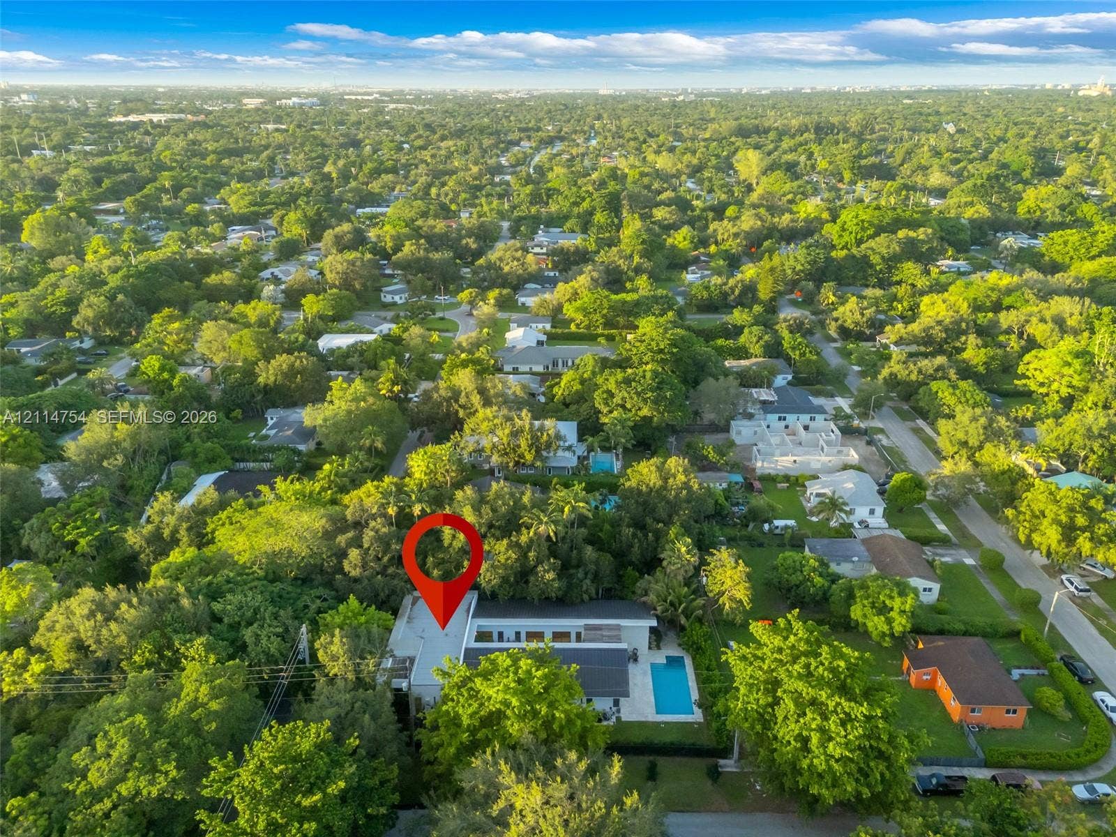 6731 SW 64th Avenue, South Miami, FL 33143 Aerial perspective showcasing a parcel characterized by dense, mature tree canopy, integrated swimming pool, and flat-roof architectural profile within a residential setting
