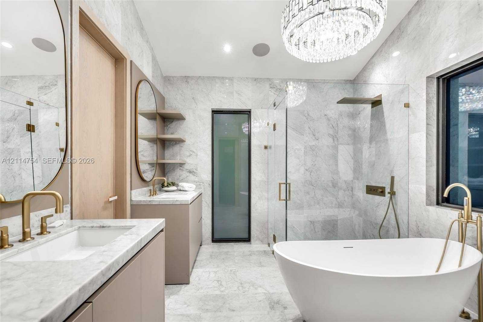 6731 SW 64th Avenue, South Miami, FL 33143 Custom walk-in closet featuring light wood-finish cabinetry, built-in drawer stacks with matte black pulls, vertical integrated LED accent lighting, full-length mirror with a black frame, and stone-finish flooring