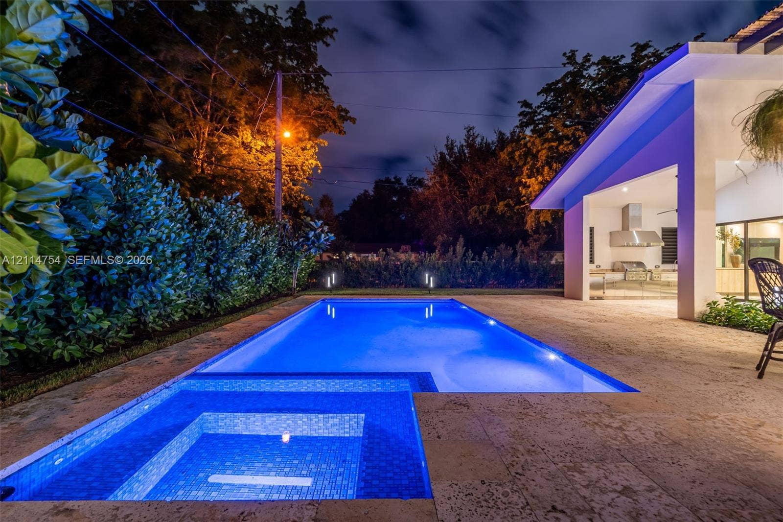 6731 SW 64th Avenue, South Miami, FL 33143 In-ground swimming pool with stone deck, covered patio, integrated pergola, and sliding glass wall systems