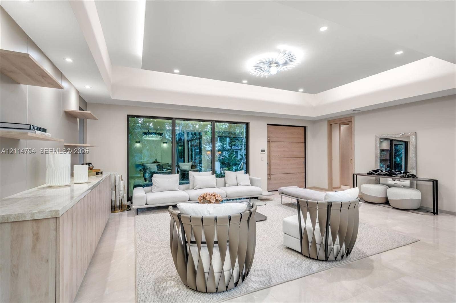 6731 SW 64th Avenue, South Miami, FL 33143 Oval LED-backlit mirror, vanity with integrated stone-finish countertop and brass-tone faucet, soft-close drawers, wall-mounted metallic shelving, and sleek low-profile commode