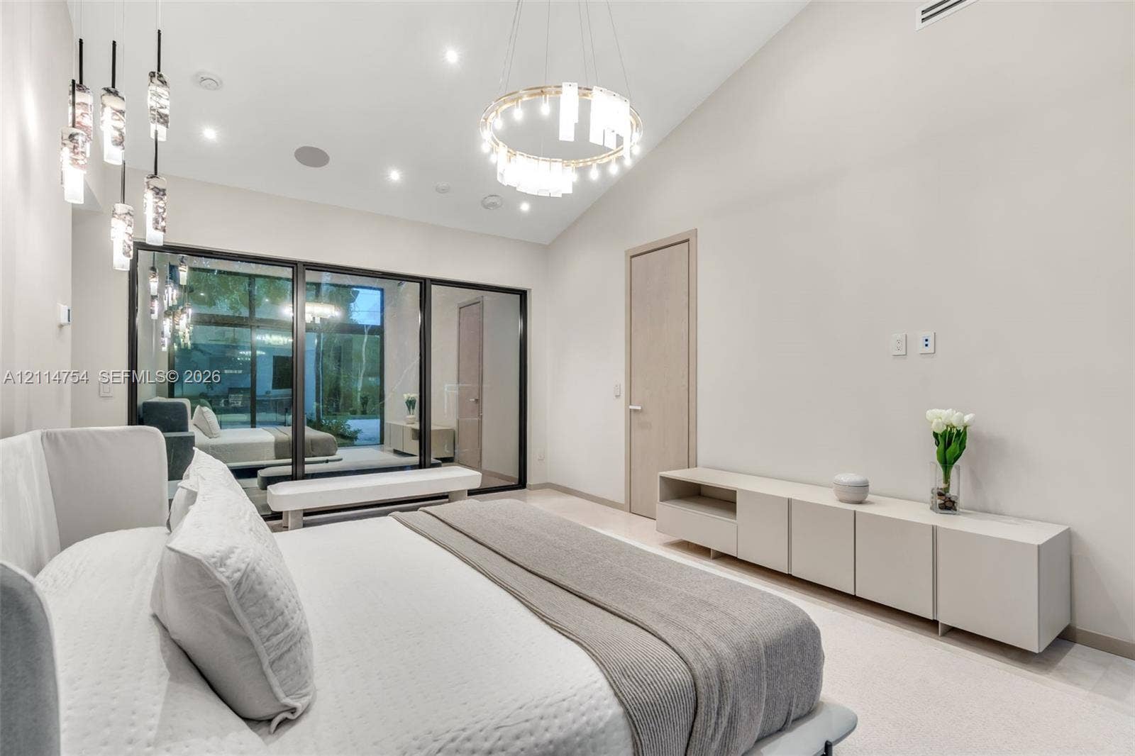 6731 SW 64th Avenue, South Miami, FL 33143 Stone tile wall and floor surfaces, glass-enclosed walk-in shower with gold-tone fixtures, freestanding soaking tub with floor-mounted faucet, and custom crystal chandelier