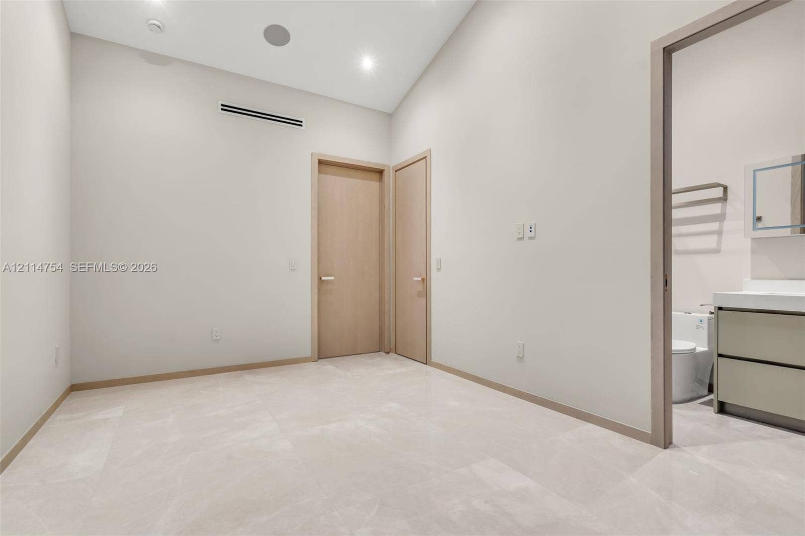6731 SW 64th Avenue, South Miami, FL 33143 High-ceiling room featuring expansive floor-to-ceiling windows, modern tiered glass pendant lighting, a circular chandelier, and built-in wall cabinetry