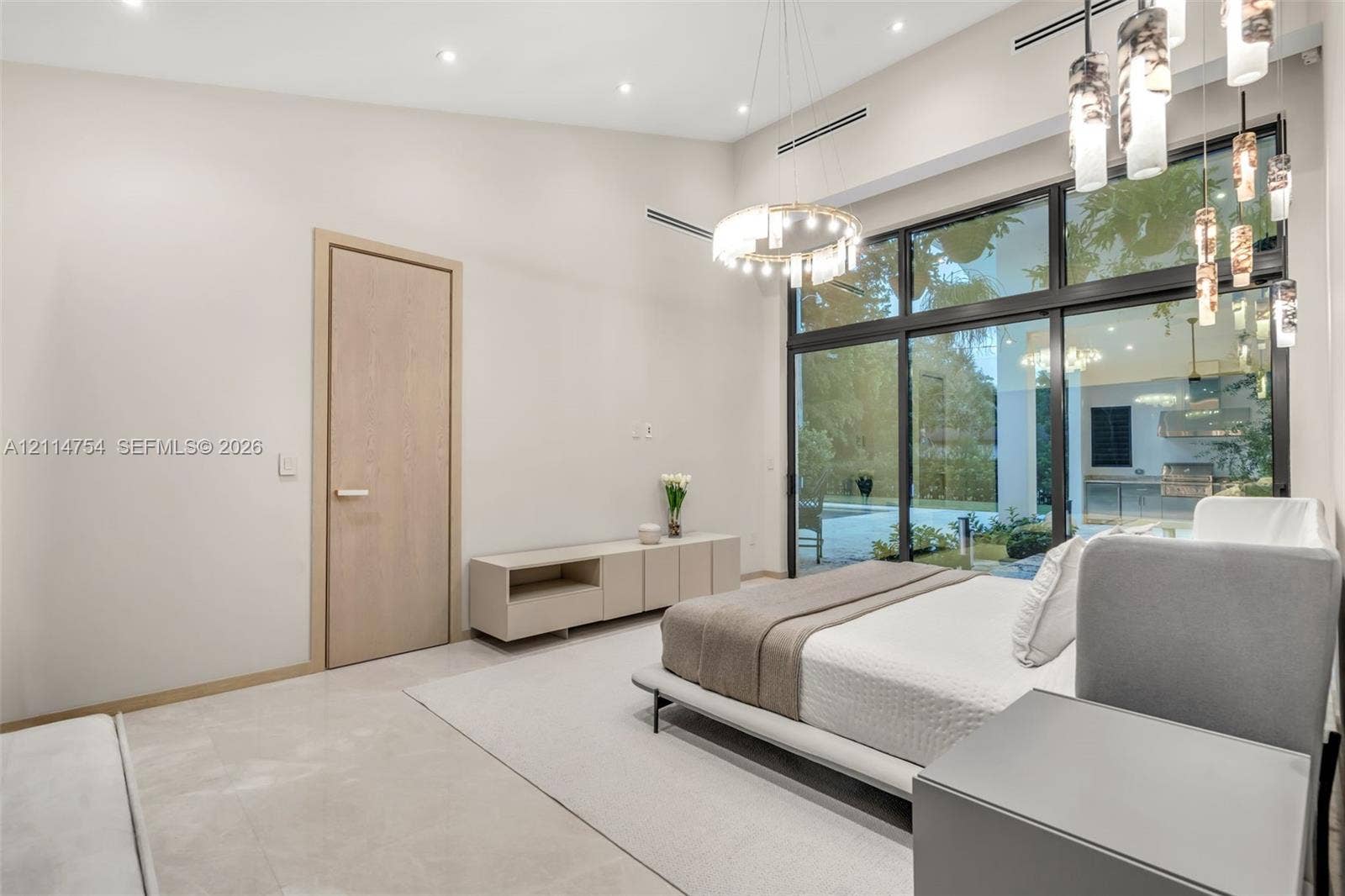 6731 SW 64th Avenue, South Miami, FL 33143 Foyer featuring large-format light-toned tile flooring, recessed ceiling lighting, a recessed tray ceiling, a large wood-finish door, and glass-paneled entry walls with black metal frames