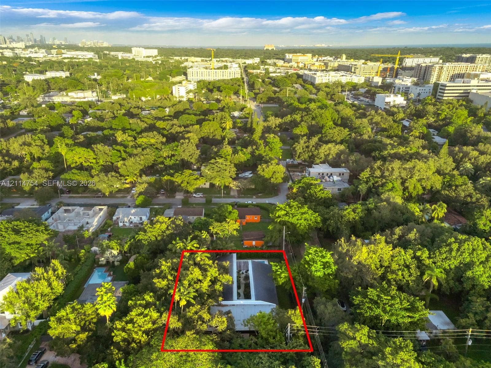 6731 SW 64th Avenue, South Miami, FL 33143 Aerial perspective featuring a metal roof structure, an integrated central courtyard, and dense mature canopy coverage