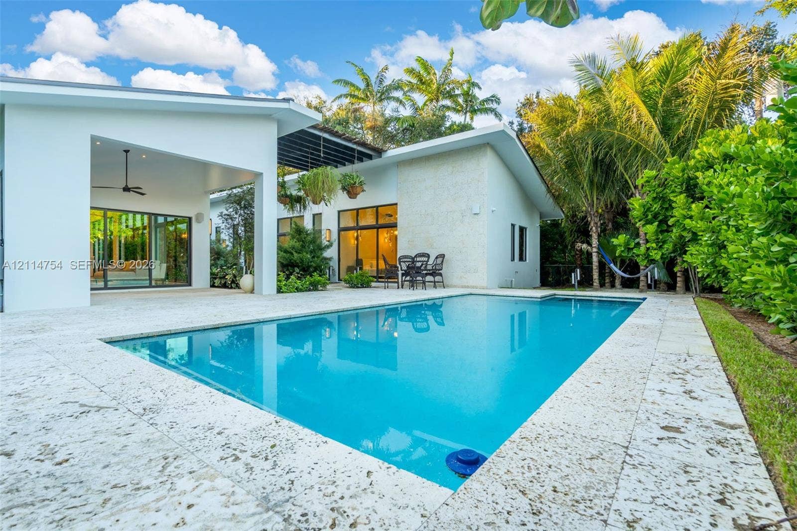 6731 SW 64th Avenue, South Miami, FL 33143 Enclosed garden courtyard featuring patterned stone pavers, desert-inspired landscaping, integrated pathway lighting, and multiple floor-to-ceiling windows