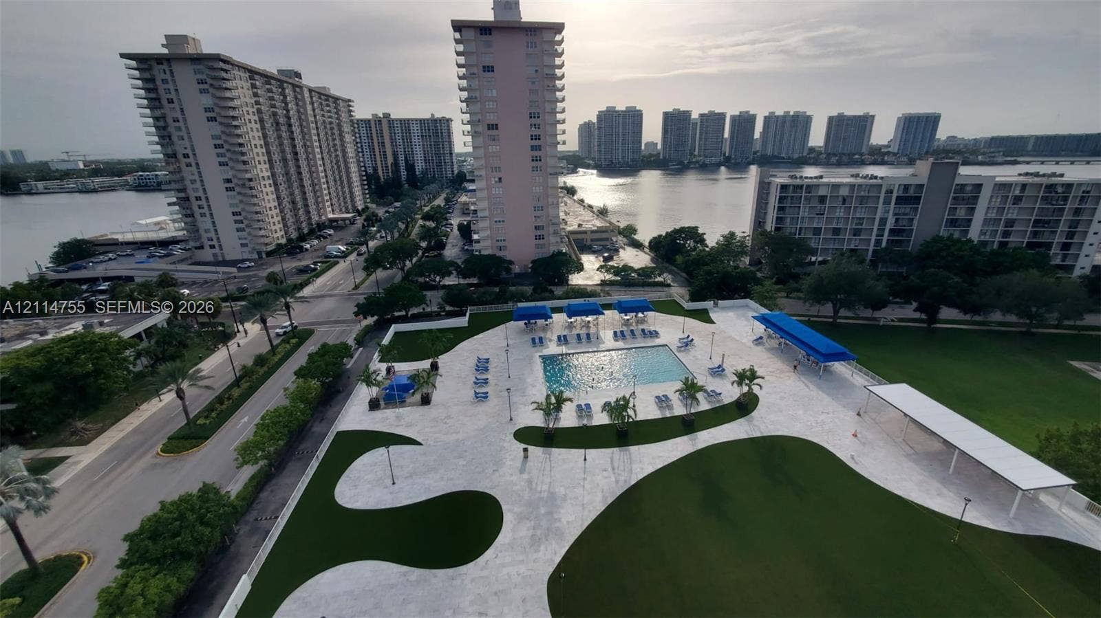 231 174th Street, #MO-3, Sunny Isles Beach, FL 33160 Outdoor swimming pool with integrated hardscaping, stone-paved deck, manicured green space, and covered cabana areas