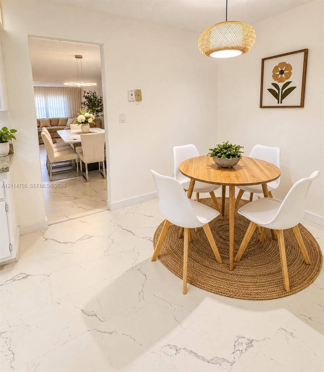 231 174th Street, #MO-3, Sunny Isles Beach, FL 33160 Large-format white stone-finish tile flooring with gray veining throughout, complemented by a woven pendant light fixture
