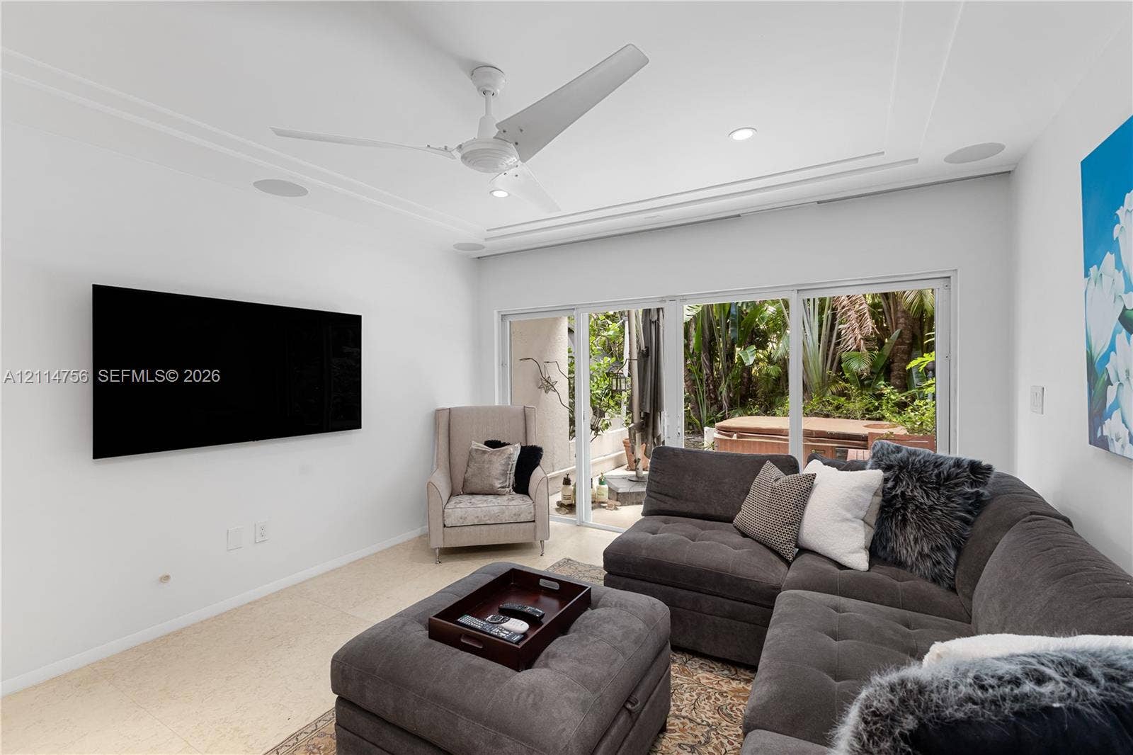 Living area featuring recessed lighting, a modern ceiling fan, stone flooring, and expansive sliding glass doors