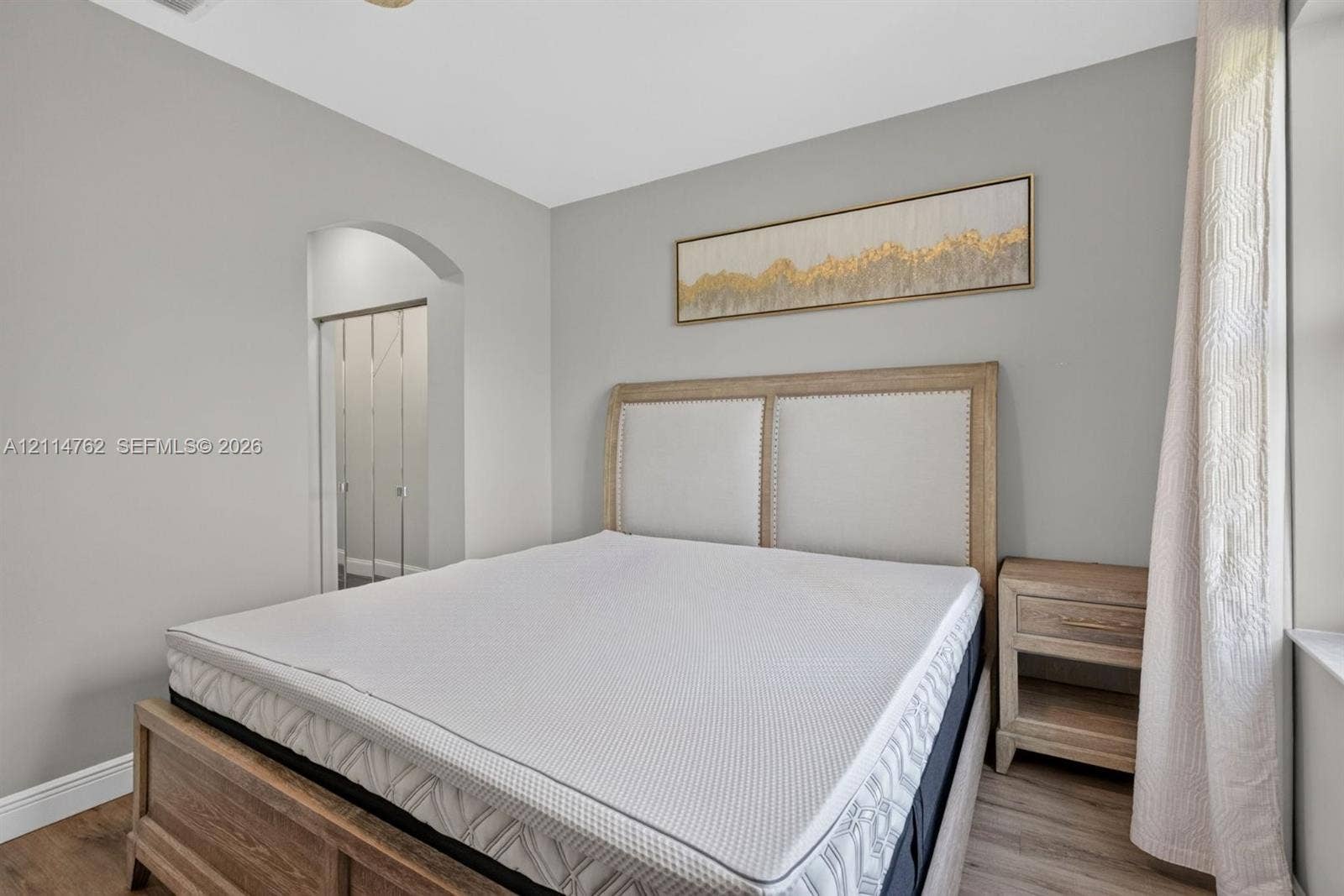662 NW 170th Terrace, Pembroke Pines, FL 33028 Neutral-toned walls featuring a structural arched entryway and wood-finish flooring