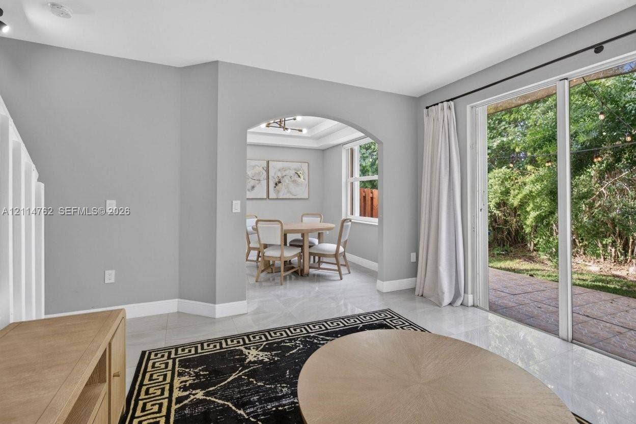 662 NW 170th Terrace, Pembroke Pines, FL 33028 Large-format tile flooring, architectural arched threshold, and sliding glass doors with direct access to a paved patio