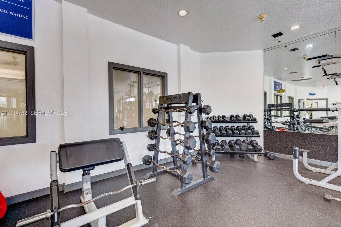 662 NW 170th Terrace, Pembroke Pines, FL 33028 Fitness center featuring recessed lighting, a full-wall mirror, and rubberized flooring