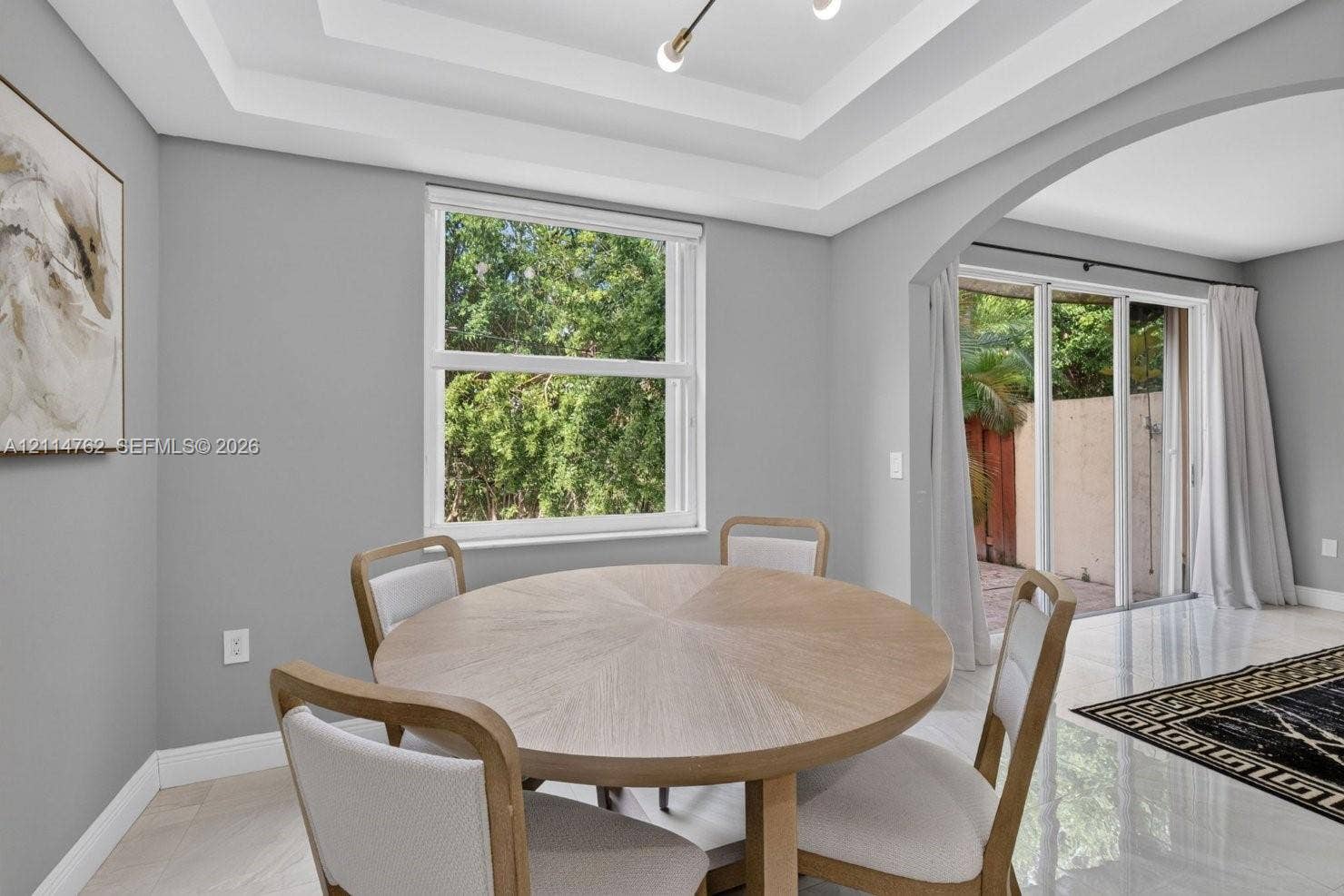 662 NW 170th Terrace, Pembroke Pines, FL 33028 Tray ceiling with recessed lighting, arched entry, single-hung window, and glass sliding doors featuring polished tile flooring