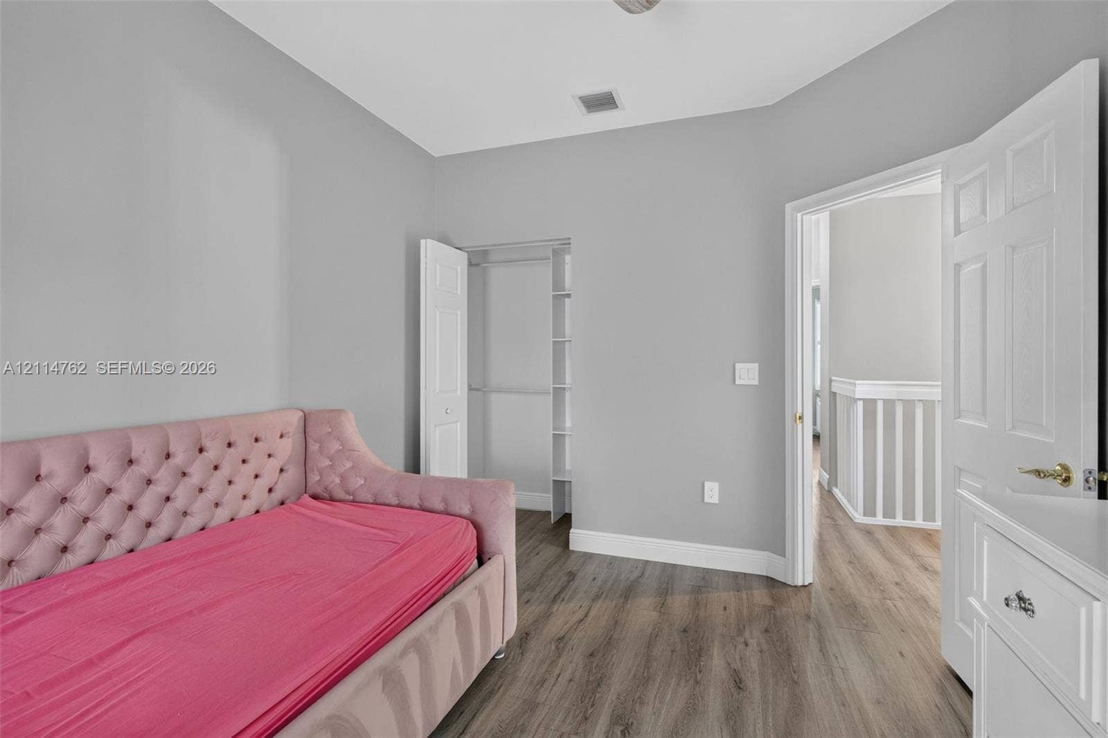 662 NW 170th Terrace, Pembroke Pines, FL 33028 Neutral-toned interior featuring wood-finish flooring, a reach-in closet with built-in shelving, and white six-panel interior doors