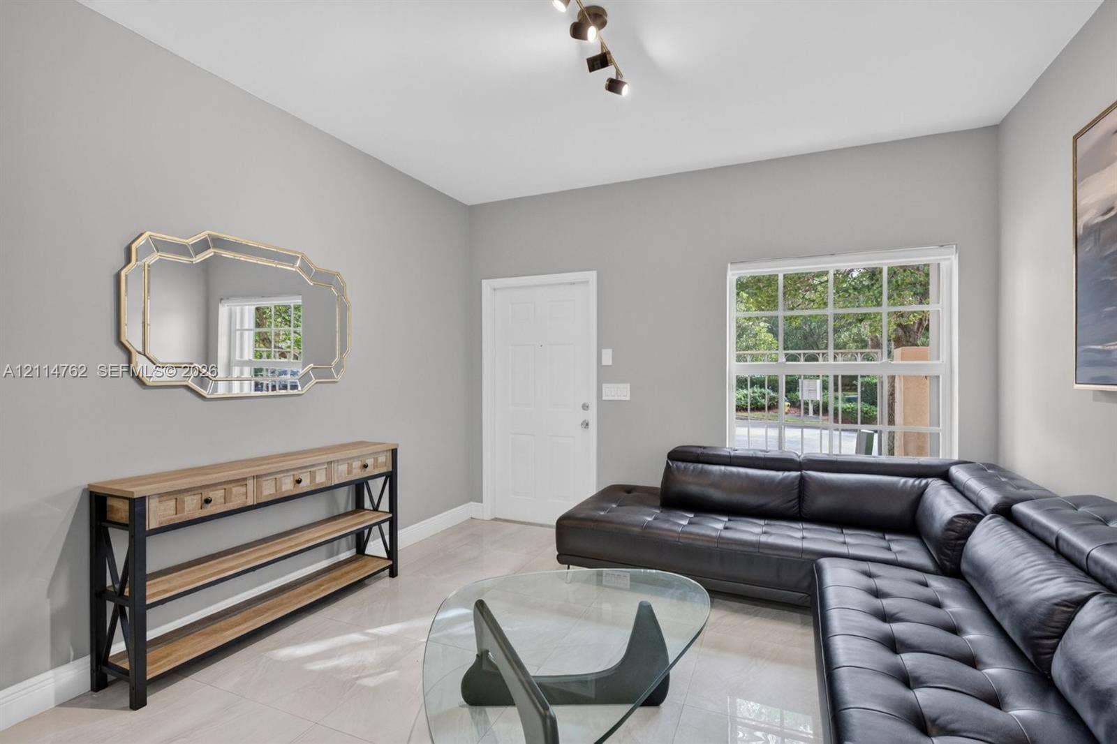 662 NW 170th Terrace, Pembroke Pines, FL 33028 Neutral interior space featuring polished tile flooring, a multi-paned window, and a modern adjustable track lighting fixture