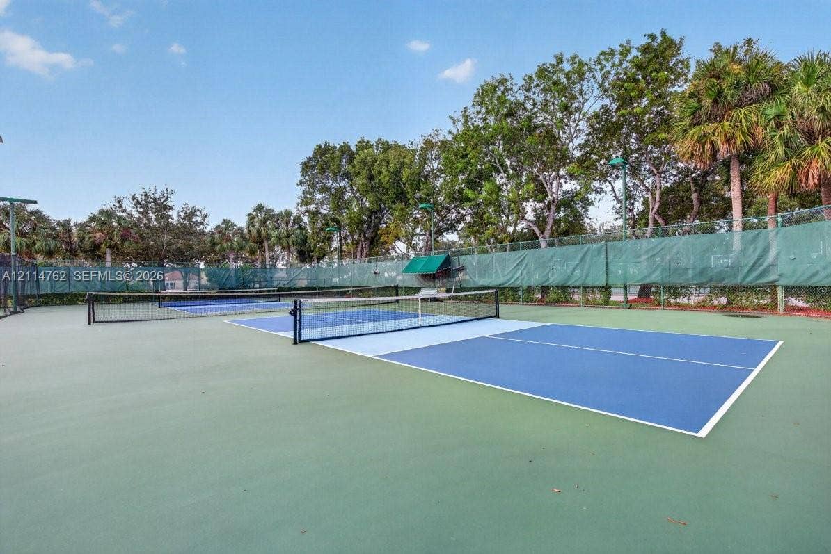 662 NW 170th Terrace, Pembroke Pines, FL 33028 Dual pickleball courts featuring specialized athletic surfacing, high-visibility nets, perimeter mesh fencing, and mature perimeter landscaping
